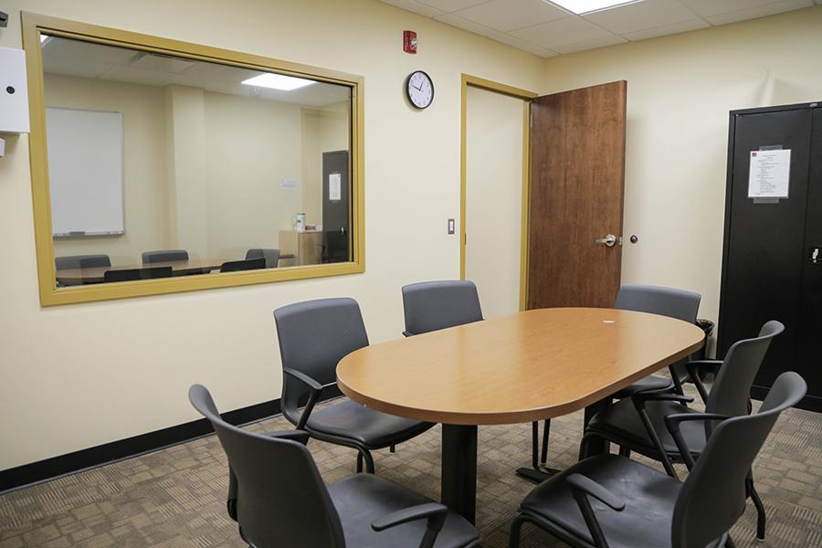 The group therapy room has an oval table in the middle and 6 chairs. There is a two way mirror so that family members can observe.