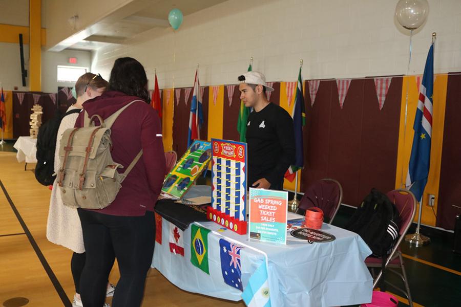 Two students talk with a member of the Iona International Club at the involvement fair.