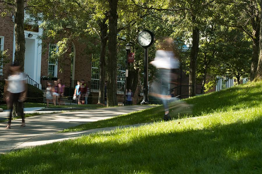 The exposure on the camera makes students walking by appear blurry and in a rush but the clock on campus is clear.