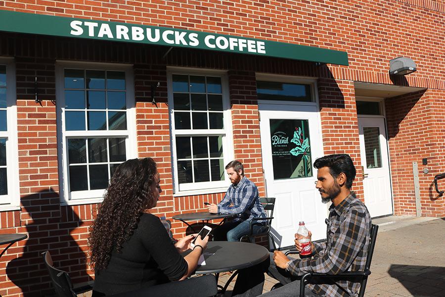 Students chatting outside of Starbucks are enjoying the sunny weather.