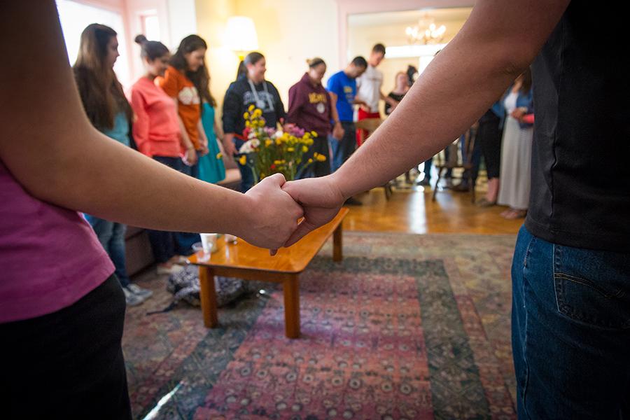 Members of the Iona Community hold hands in a circle and pray at the chapel