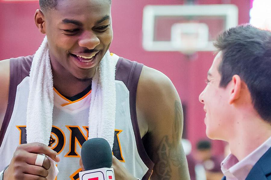 An Iona basketball player gets interviewed after the game by a Sports Comm major.