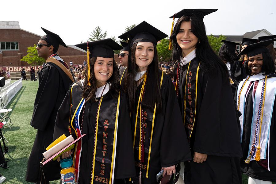 Three graduates at the 2023 Commencement.
