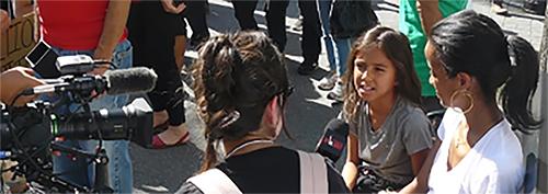 A young girl is interviewed by a journalist.