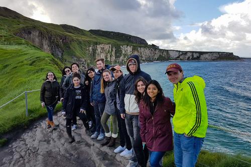 A group of Iona students pose with white cliffs behind them in Ireland.