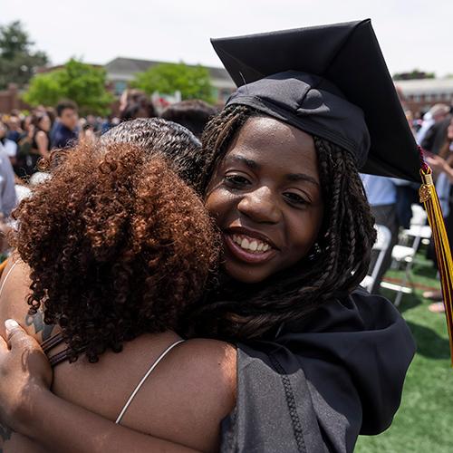 A 2023 graduate hugs her family member.