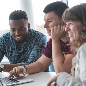 three students collaborating at a table