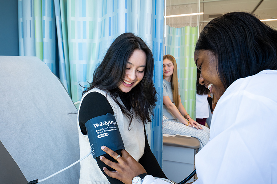 A medical student in an early acceptance program practices measuring blood pressure.
