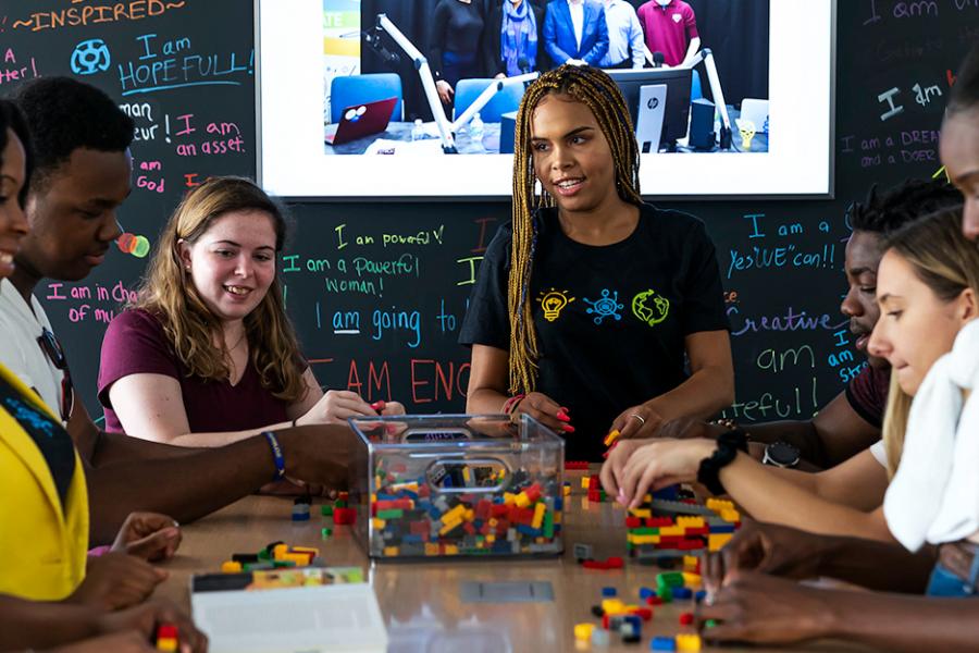 A group of students collaborate together with a professor in the Hynes Institute for Entrepreneurship.