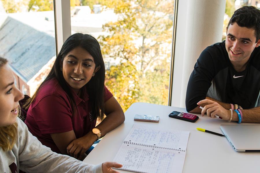 Three sociology students sit together and chat in a lounge in the North Ave residence hall.