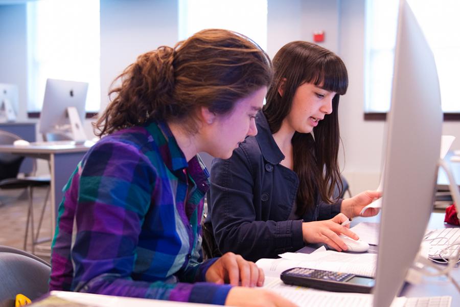 Two students work in the computer lab for their business analytics minor.