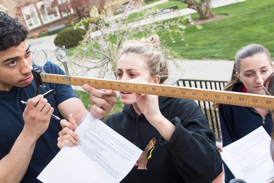 A group of physics students work outside for a class.