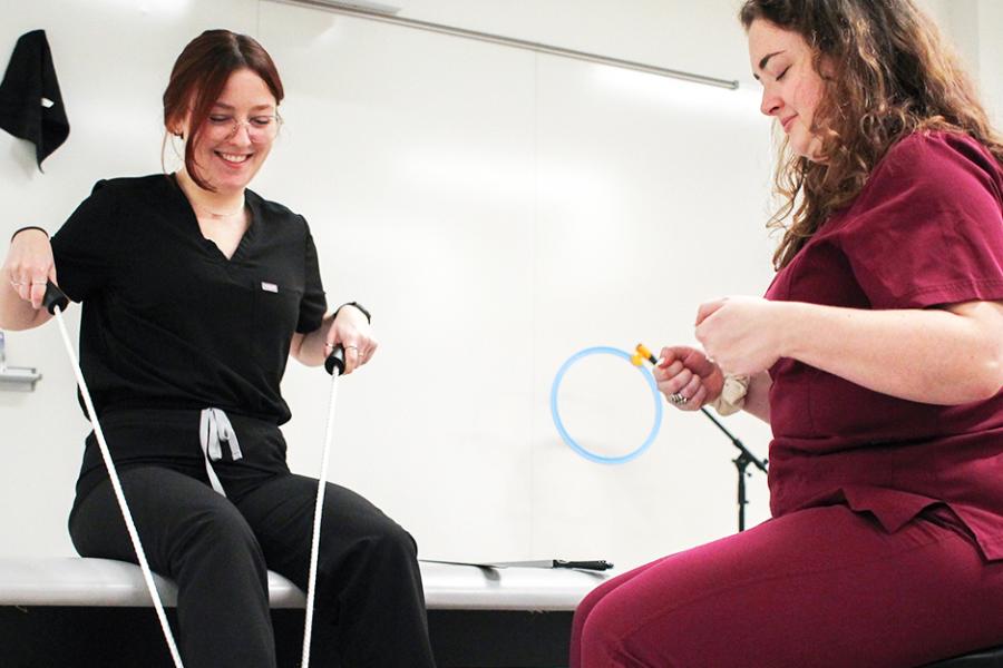 OT students practice putting on a shoe with a shoe strap.