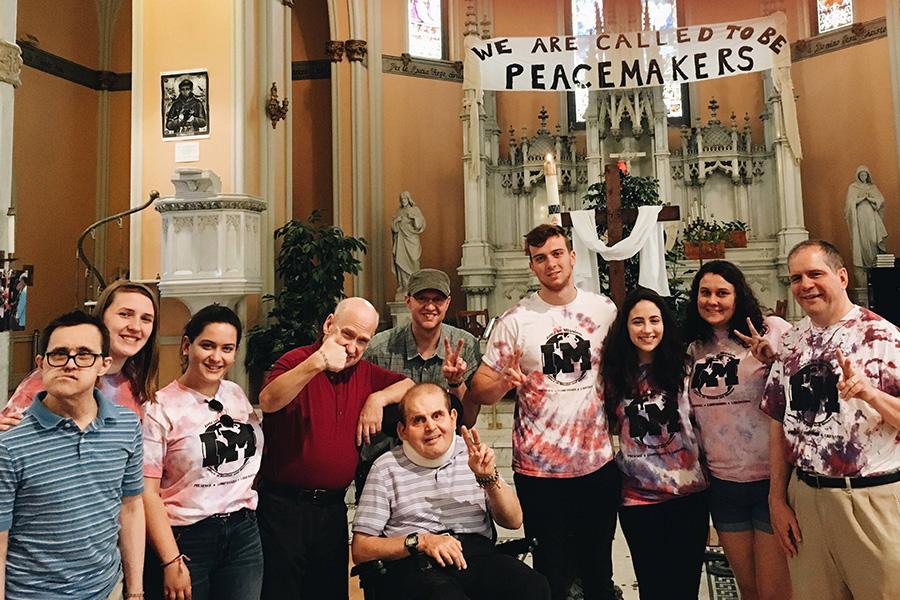 Mission and Ministry students at a church where they serve. A banner in the background reads We are the Peacemakers.