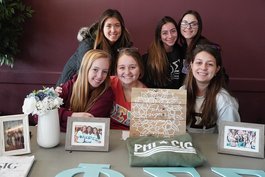 The members of Phi Sigma Sigma at their table at the involvement fair.