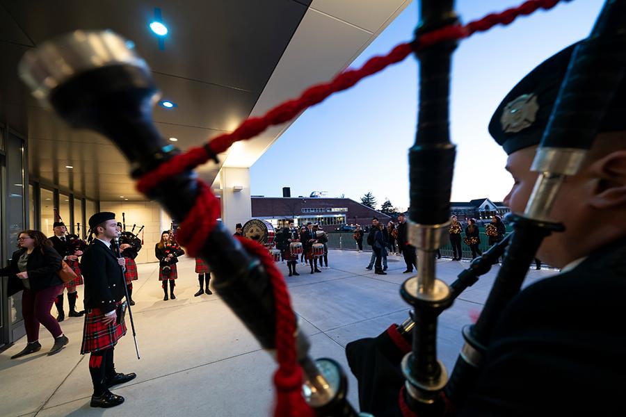 Pipers play outside of the LaPenta School of Business during the ribbon cutting.