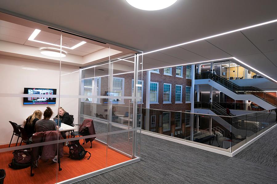 Students study in one of the glass-enclosed spaces at the LaPenta School of Business.