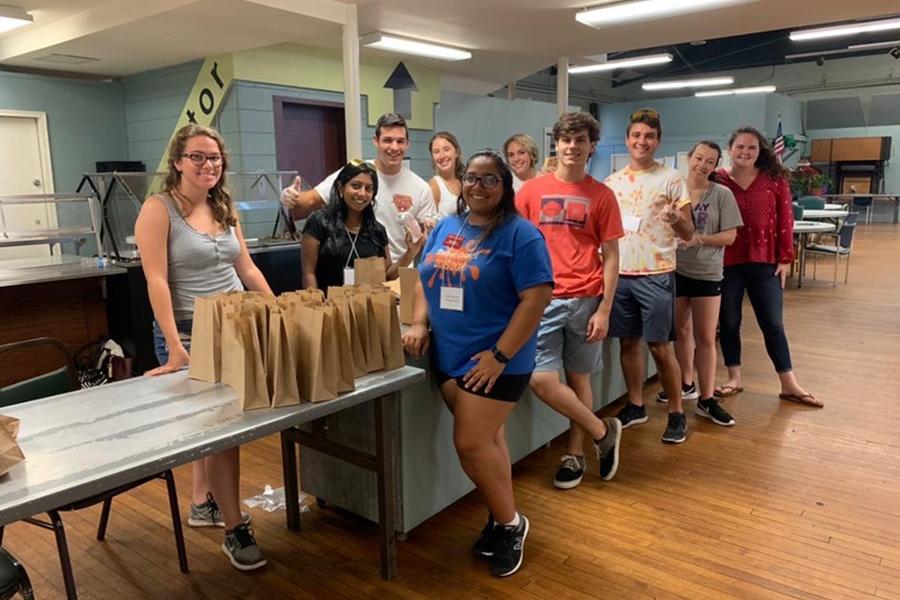 A student club fills lunch bags for an event.