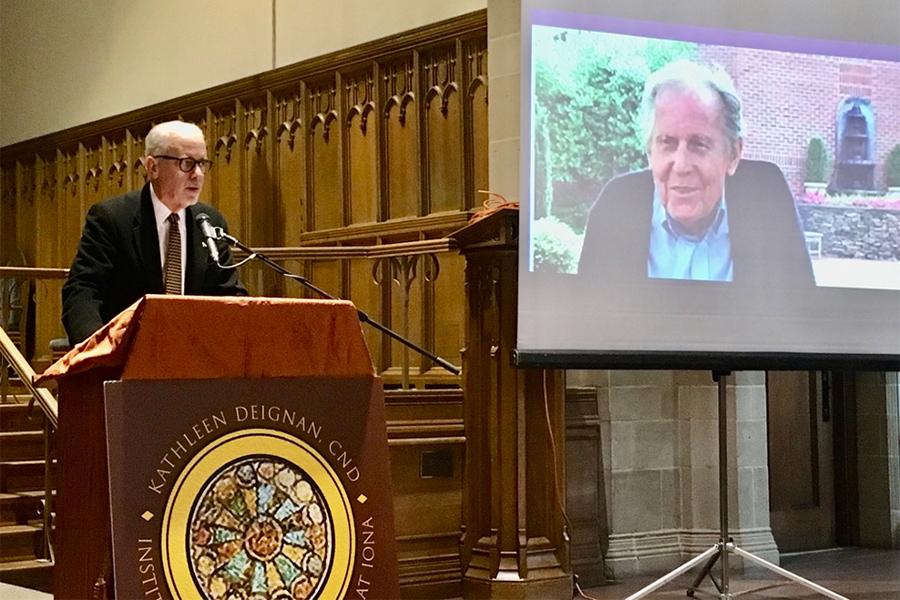 Brother Kevin Cawley stands at a podium in the Arrigoni Center.