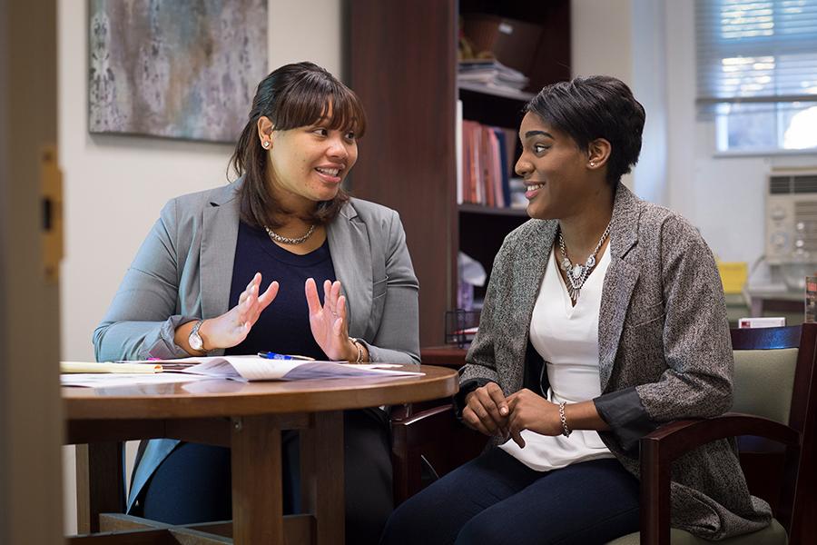 An advisor sits with a student and talks to her about which classes to take next.