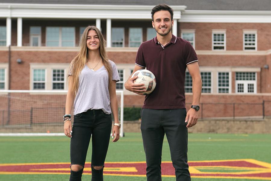 Humbert and Andrea Ferrer at Mazzella field. Humbert cradles a soccer ball.