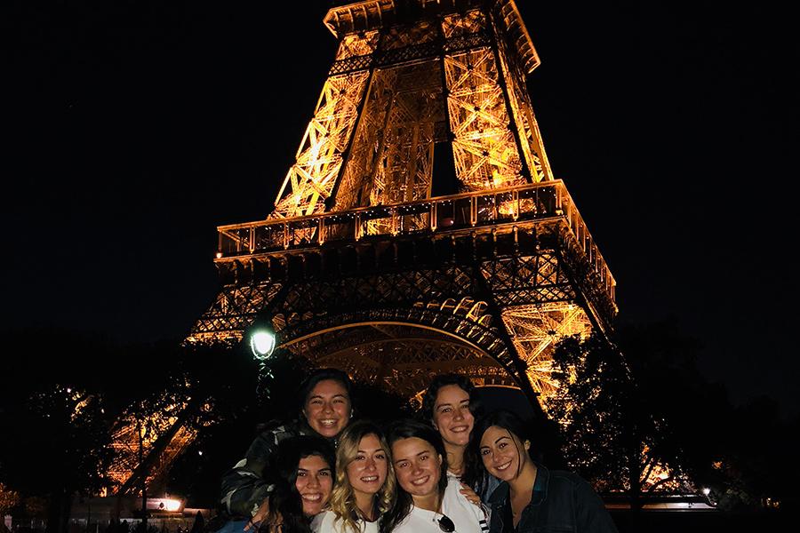 A group of Iona students in front of the Eiffel Tower at night in Paris, France.