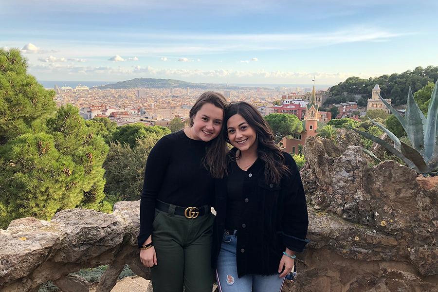 Two Iona students pose on a sunny day with Barcelona, Spain in the background.