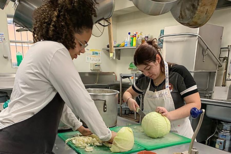 Two students chop lettuce in a soup kitchen on the mission trip to Philadelphia.