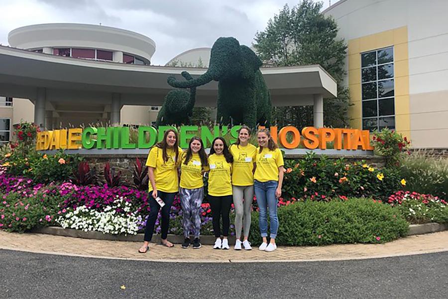 Four students at an Iona Mission Trip at a children's hospital.