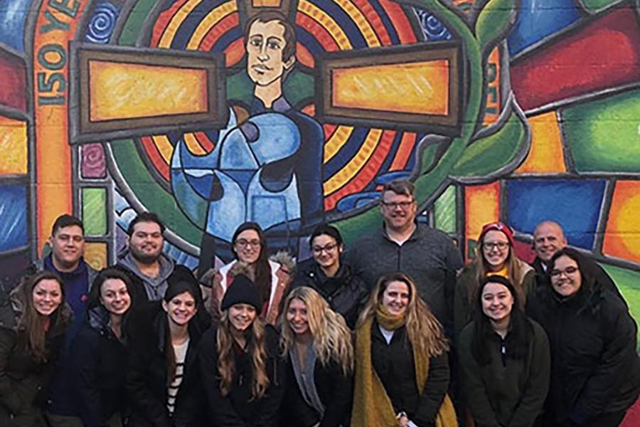 Iona students stand in front of a mural of Blessed Edmund Rice on the Ireland mission trip.