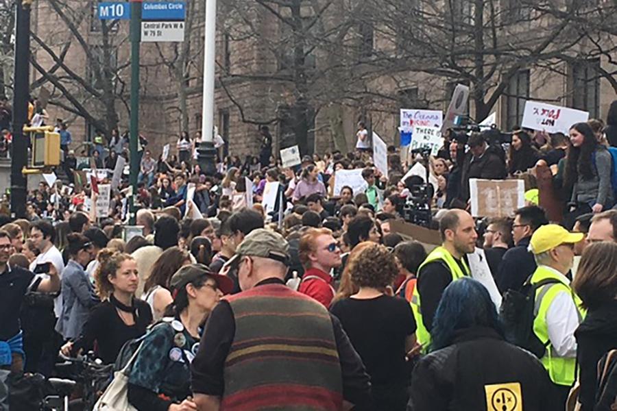 Demonstrators gather in a crowd in the street to raise awareness for climate change.