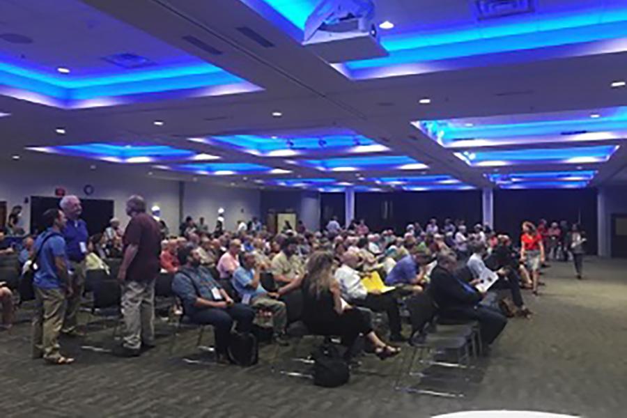 A lecture session in progress with a large crowd of listeners at Creighton University.