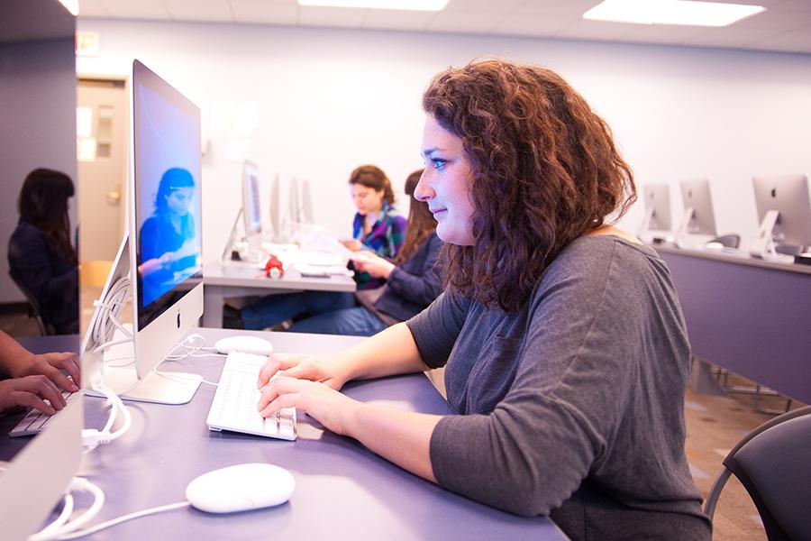 A student sits at her Mac desktop in one of the computer labs.