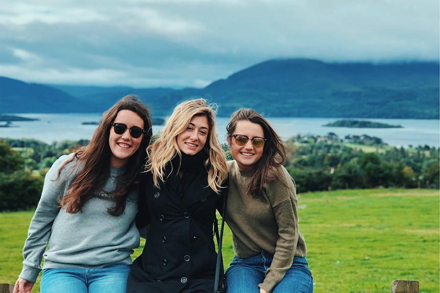 Three Iona students pose together on a green hill in Ireland.