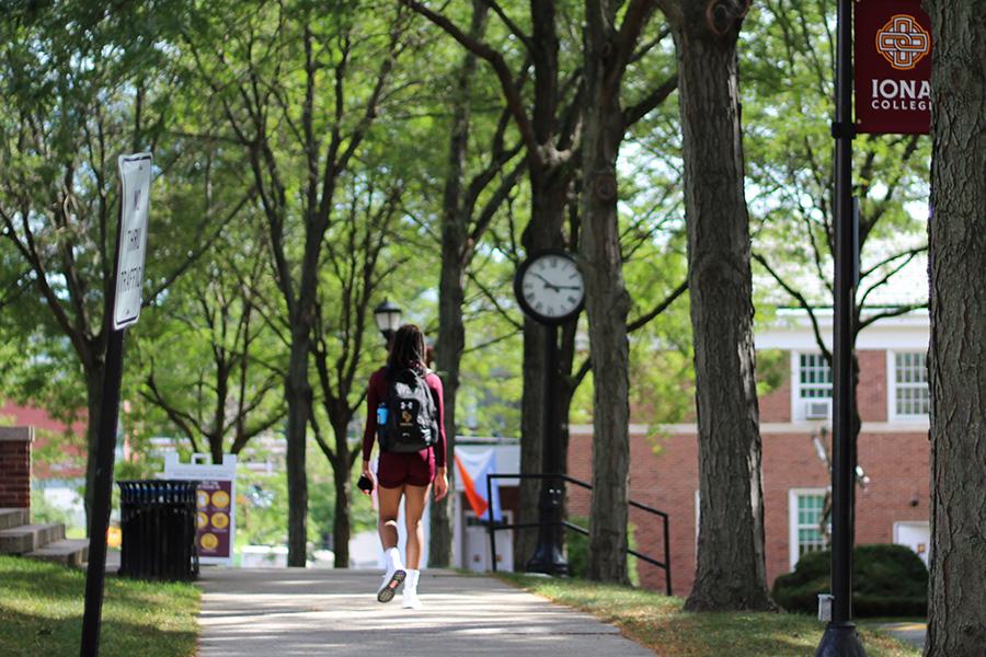 A male student walks down the main pathway of campus.
