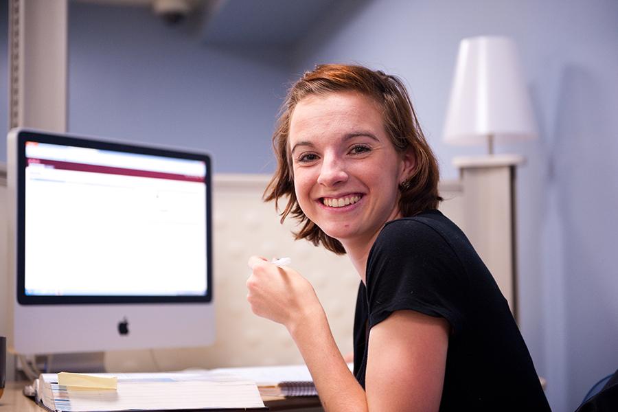 A student logs in to her MyIona account and turns around and smiles.