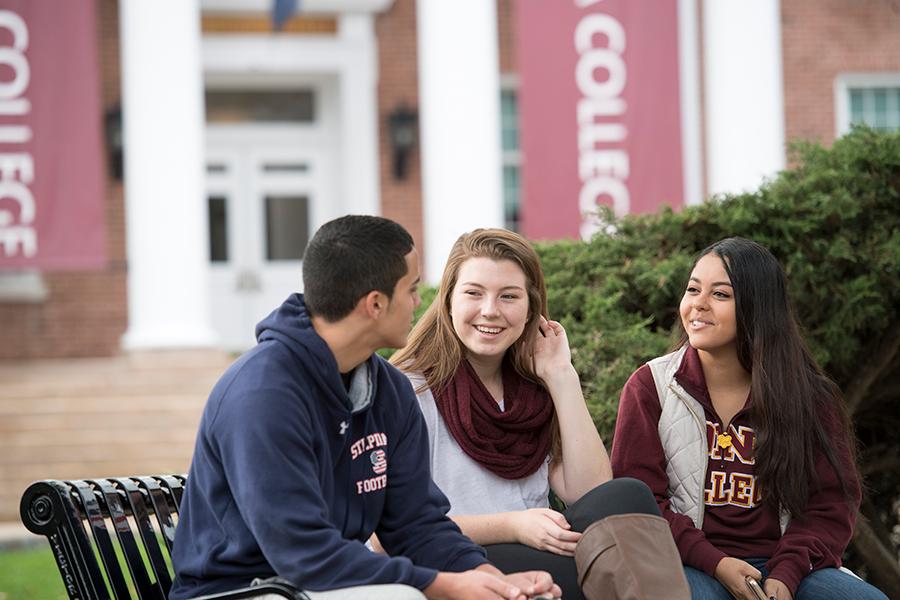 Three students from the clinical communication certificate program sit outside and talk.