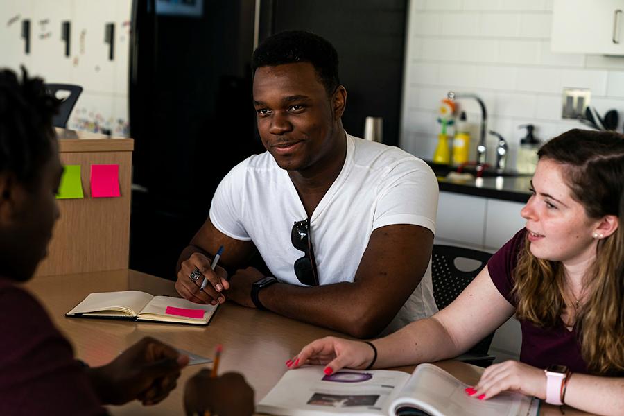 Three entrepreneurship students work at a table in the Hynes Institute.