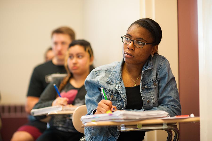 A student takes notes in her math class.