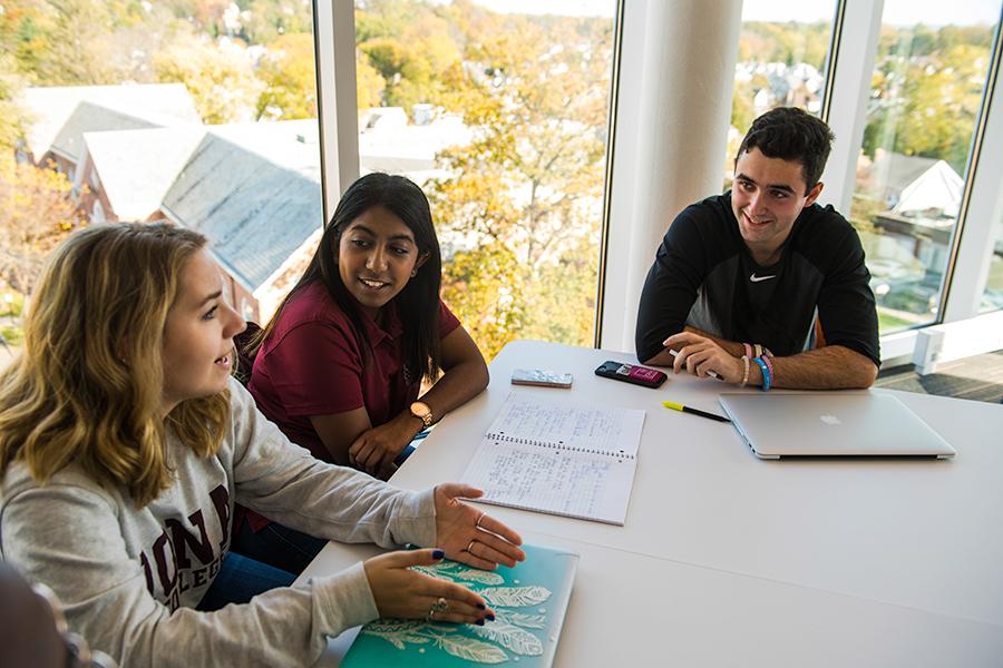 Three sociology students sit together and chat in a lounge in the North Ave residence hall.