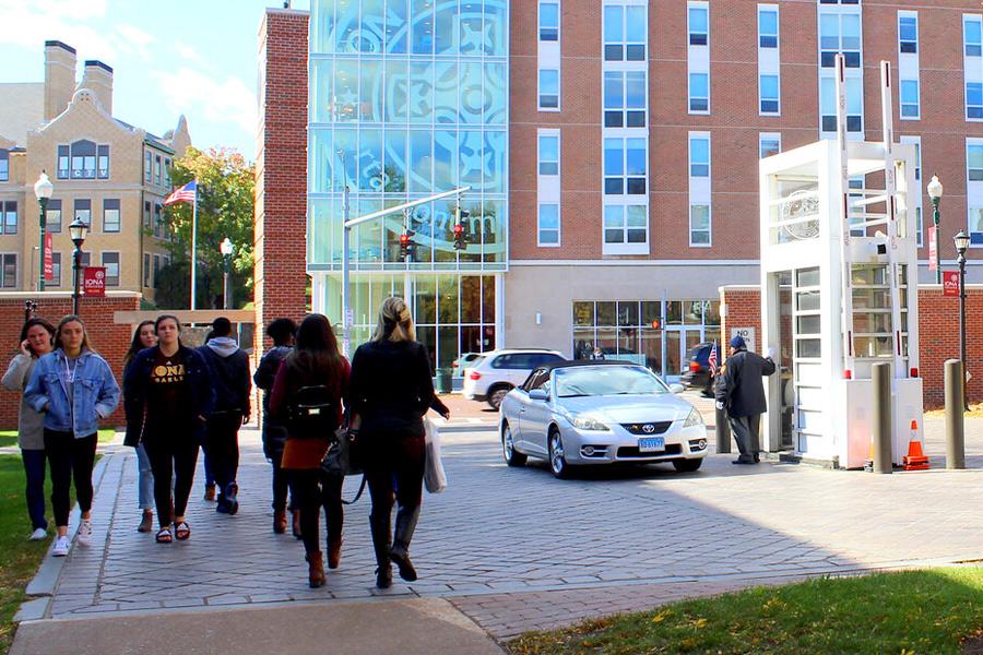 Students walk on the sideway outside the Ryan Library with North Avenue and buildings in the background.