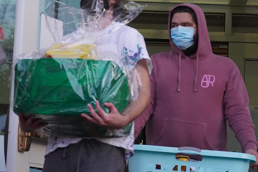 Two students carry Thanksgiving baskets out of the Hynes Center.