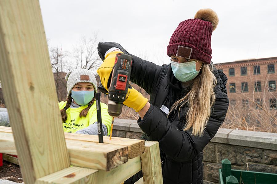 A student drills a bench together at the Fuller house in Yonkers.