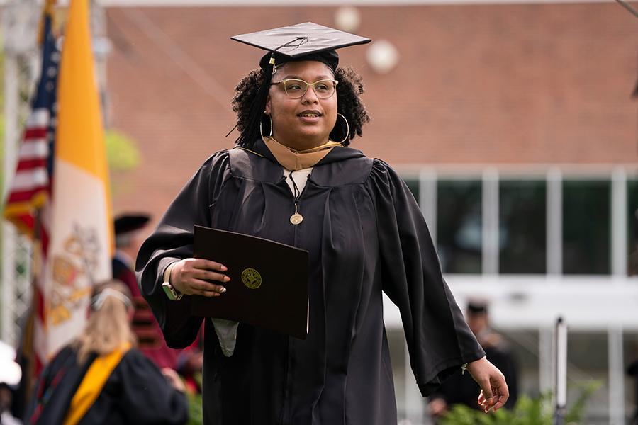 A student walks with her diploma at the 2021 in-person recognition ceremony.