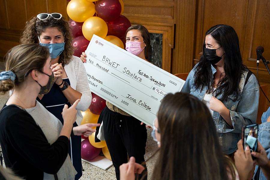 A student holds the BHWET check.