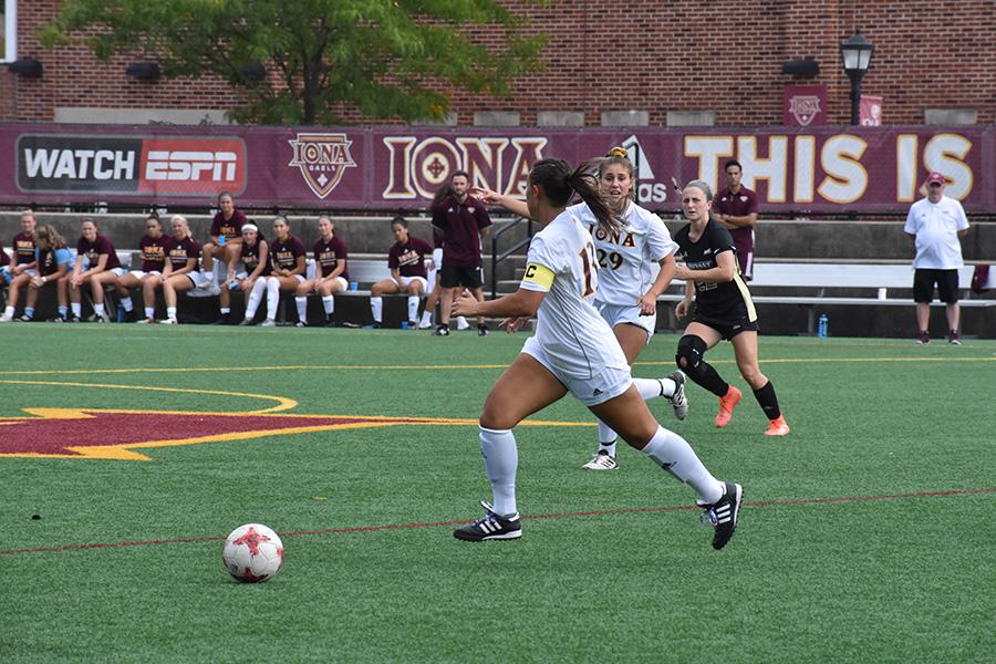 An Iona Women's Club soccer player kicks the ball down field.