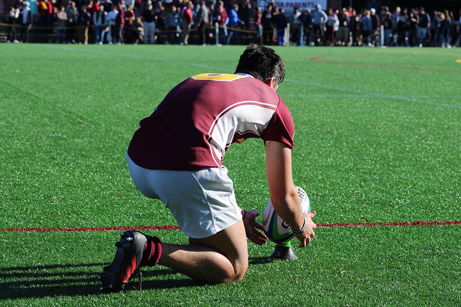 An Iona College rugby player sets up the ball.