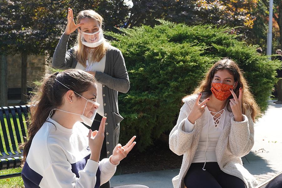 Dr. Michelle Veyvoda signing with students at Iona College.