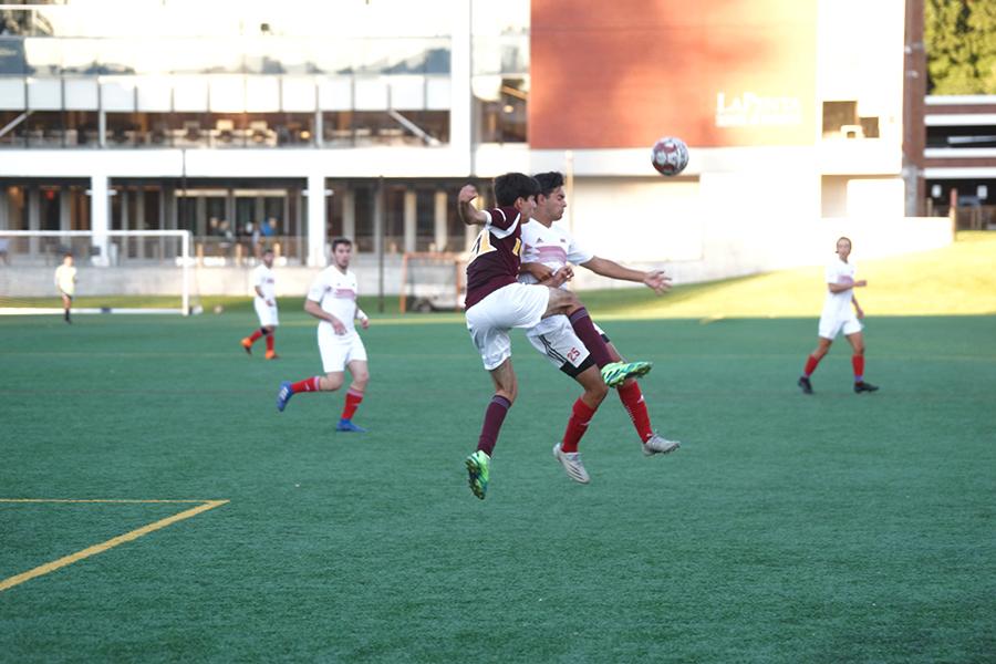 Iona men's club soccer jump to get the ball.