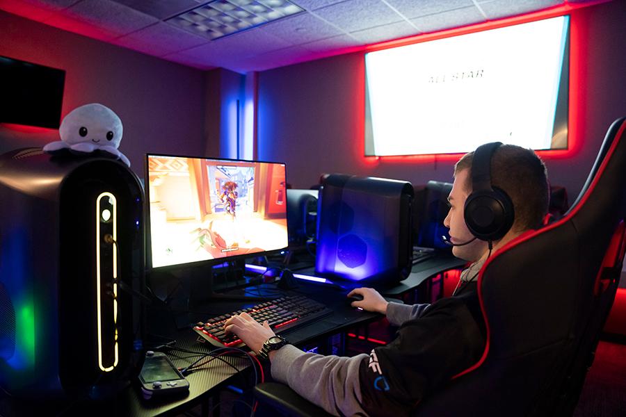 A student plays a video game facing away the cameras.